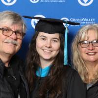 A future graduate and her parents smile for a photo together at Gradfest